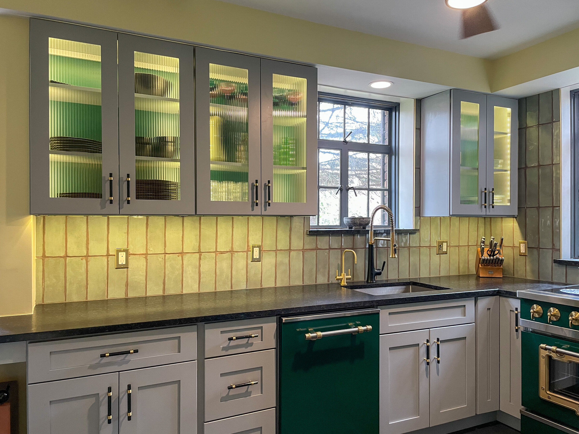 Kitchen remodel with green tile backsplash, fluted glass cabinets, and emerald green range and dishwasher - Marcus Sebastian Renovations